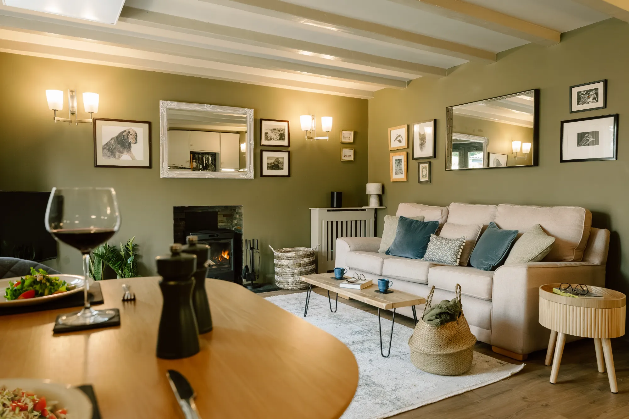 Luxury stone cottage living room at The Rookery featuring a lit wood burner fire, moody interior design, and a cosy seating area at The Roost Retreats.